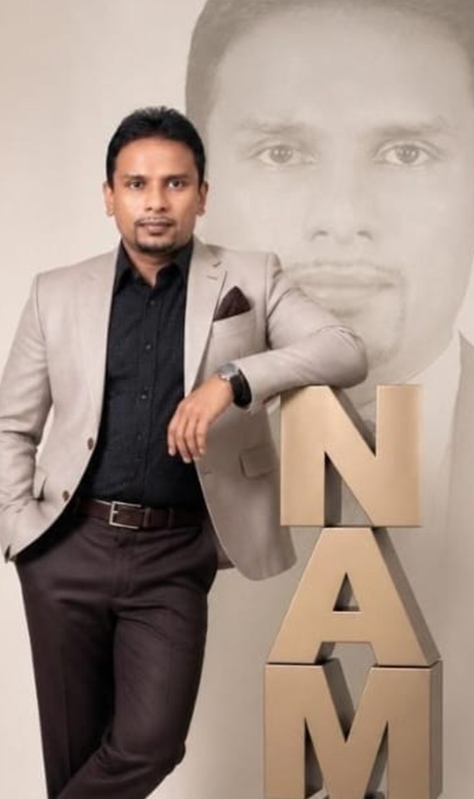Namal Wijesinghe standing beside three-dimensional letters spelling his name.